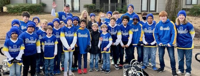 A group of kids and teens standing in front of a house